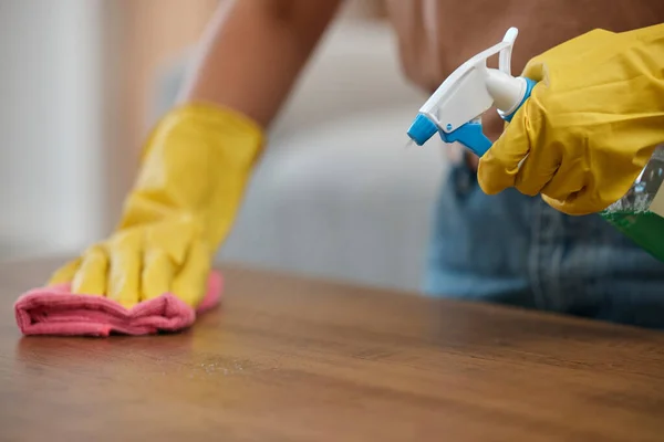 Person, cleaning and table with gloves, spray and closeup by maintenance, housekeeping and detergent for bacteria. Hands, cloth and fresh for service, cleaner and home by chemical, furniture and dust.