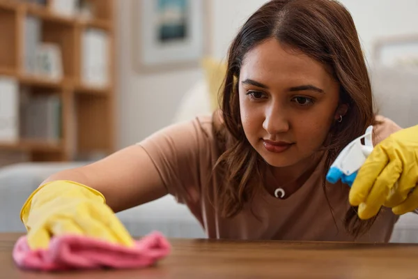 Woman, cleaning and table with gloves, face and spray at home, detergent and housework in fresh, living room and maintenance. Mexican person, cloth and housekeeping for bacteria, furniture or surface.