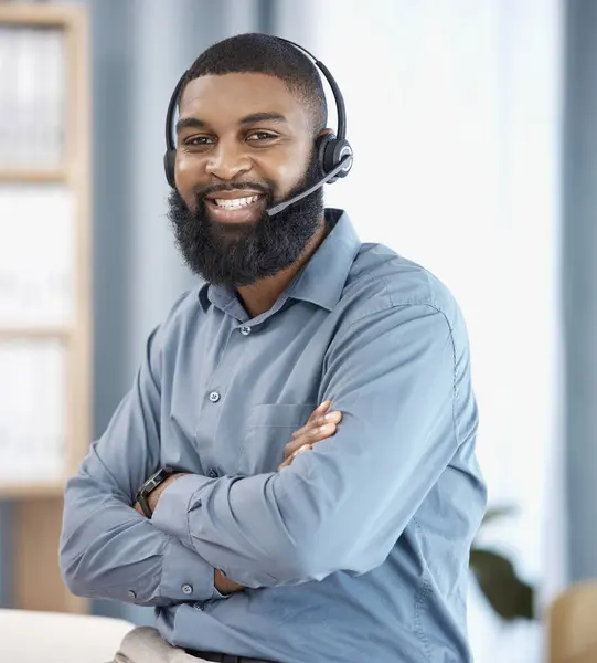 Man, call center and arms crossed in office, portrait or confident, pride or telemarketing job with smile. African CRM, consultant or customer support agent with microphone, headphones or networking.