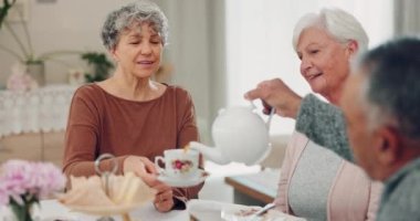 Kıdemli adam, kadınlar ve özenle çay doldurmak, emeklilikte içmek ve sohbet etmek, çay fincanı ve evde gülümsemek. Yaşlı grup, evde sosyal etkinliklerle kahvaltıda sohbet edin ve rahatlayın..