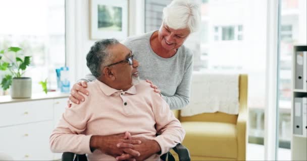 高齢者 異人種間のカップル 結婚と愛のある病院での会話 車椅子 シニアマン 共感のある女性 患者ケア 笑顔で健康診療クリニックでのサポート — ストック動画