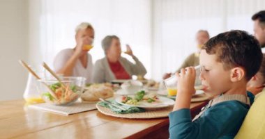Aile, öğle yemeği ve yemek masasında portakal suyu içen bir çocuk. Bu arada evlerinde yemek yiyip yemek yiyorlar. Aşk, yemek ve meyveli susamış çocuk kahvaltıda anne ve babaanne ve büyükbabayla birlikte içecek..