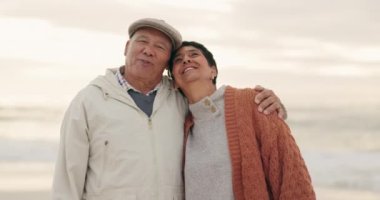 Yaşlı çift, sahildeyken sarılıp sohbet ediyorlar, birlikte mutluluk ve emeklilik, seyahat ve dışarıda özgürlük. İletişim, mutlu insanlar ve tatil ile emeklilik, evlilik ve gün batımıyla bağlılık.