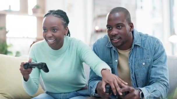 非洲夫妇 电子游戏控制器和沙发与竞赛 游戏和推动与漫画笑 家庭和运动 黑人女性 男性和网络游戏 虚拟用户体验和休息室的竞争 — 图库视频影像
