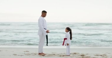 Deniz, karate öğretmeni ya da çocuk dövüş sanatları öğreniyor, dövüş ya da fitness koçluğu için kendini savunma. Eğil, saygı duy ya da sahil kenarında bir çocuğa, kıza ya da öğrenciye antrenman, egzersiz ya da eğitim öğret..