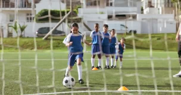スポーツチームは キック目標または若者の開発のための練習を撮影する子供の祝い サッカーボールと目標 サッカー選手のスコア グループサポート ネットまたはフィールドでの子供のトレーニング — ストック動画
