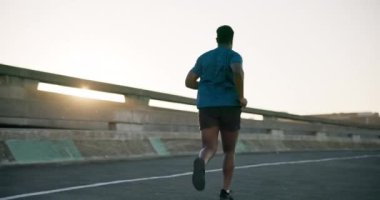 Siyah adam, spor için gün batımında yolda koşmak, spor yapmak, açık havada egzersiz yapmak ya da şehirde kardiyo çalışmak. Aktif erkek, atlet ya da sporcu, sağlıklı sağlık ya da zayıflamış sporcuların arka görüşü.