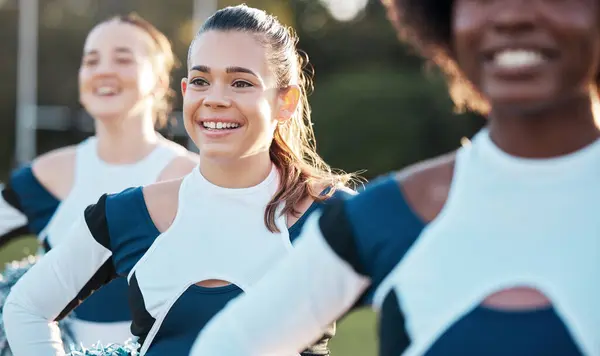 Cheerleader team, sports and women on field for performance, dance and motivation for game. Teamwork, dancer and people in costume cheer for support in match, competition and sport event outdoors.