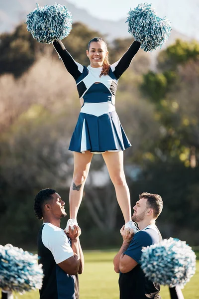 Cheerleader, sports and men balance woman on field for performance, dance and game motivation. Teamwork, dancer and people in costume cheer for support in match, competition and event outdoors.