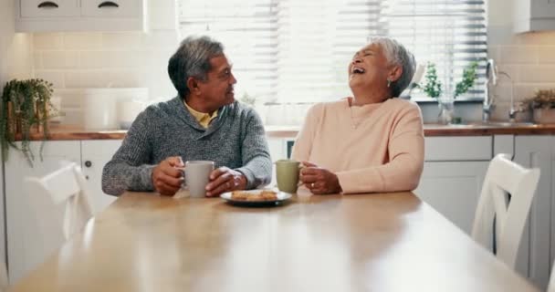 上了年纪的夫妇 在厨房里笑着 和咖啡 退休和在家里聊天联系在一起 快乐的人 在家里和饼干 饼干或早茶一起在早餐桌上开玩笑或开玩笑 — 图库视频影像