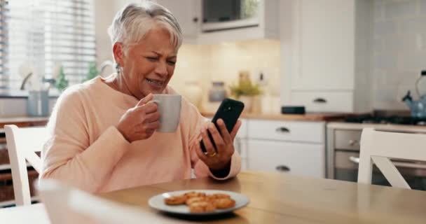 快乐的老年女性 电话和咖啡与滑稽视频 社交媒体帖子或流媒体喜剧在她家厨房 老年人在手机聊天 网络迷因 喝茶和饼干时大笑 — 图库视频影像