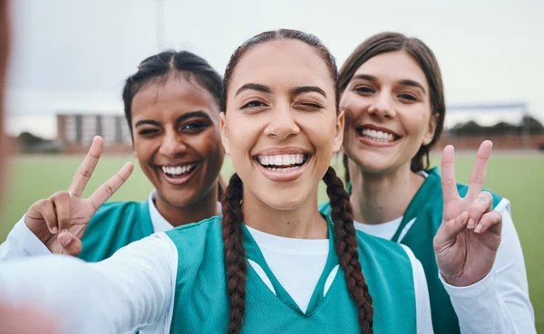 Sports selfie, girl team and peace sign on field for memory, competition and portrait for fitness. Women group, photography and wink on social network with emoji, v icon and diversity for hockey game.