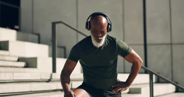 成熟した男 スマートウォッチと健康と思考のための心拍数で都市で運動 アフリカ系アメリカ人 疲れて 屋外でポッドキャストとブレイク トレーニングとヘッドフォンで音楽を聞く — ストック動画
