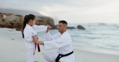 Plaj, karate ya da bir baba ve kızıyla birlikte dışarıda nefsi müdafaa egzersizi. Erkek bir ebeveyni olan eğitim, aile ve çocuklar kızına deniz ya da okyanus kenarında nasıl dövüşüleceğini öğretiyor..