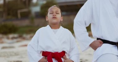 Plaj, karate öğretmeni ya da çocuk dövüş sanatları öğreniyor, dövüş ya da fitness koçluğunda farkındalık. Nefes almak, tai chi ya da master yapmak bir çocuğa, kıza ya da öğrenciye antrenman, egzersiz ya da denizdeki eğitimi öğretmek.