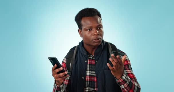 在工作室里 一个愤怒的黑人男人带着旅行压力 遗失或蓝色背景的小故障 在远足 失败和扬声器电话中 智能手机 问题和男性对应用程序 404或地图 位置和向导错误感到沮丧 — 图库视频影像