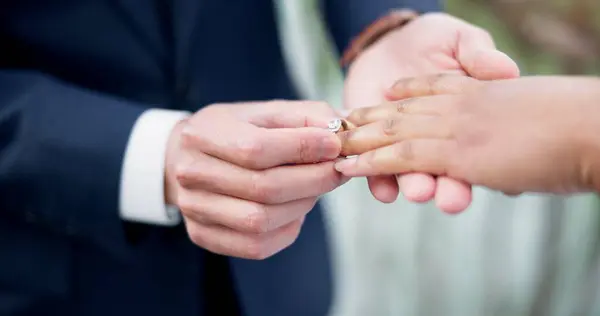 Couple, hands and ring for marriage, commitment or wedding in ceremony, love or support together. Closeup of people getting married, vows or accessory for symbol of bond, relationship or partnership.