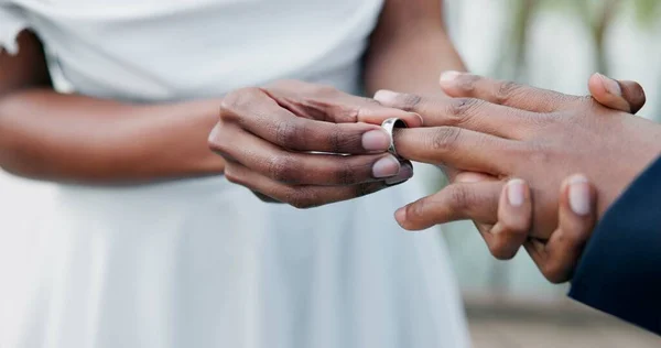 Couple, holding hands and ring for marriage, commitment or wedding in ceremony, love or support. Closeup of people getting married, vows or accessory for symbol of bond, relationship or partnership.