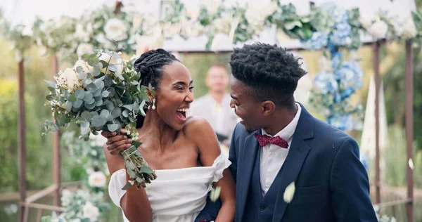 Couple, flower confetti and outdoor wedding with event, walk and happy laugh in nature. Black woman, man and excited for marriage, floral bouquet or holding hands in park, party or together in aisle.