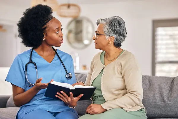 Bible, religion and assisted living caregiver with an old woman in a retirement home together. Healthcare, christian faith or belief with a nurse or volunteer reading to a senior patient in a house.