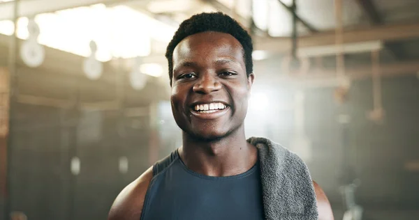 Happy, fitness and face of black man at a gym for training, exercise and athletics routine. Smile, portrait and African male personal trainer at sports studio for workout, progress and body challenge.