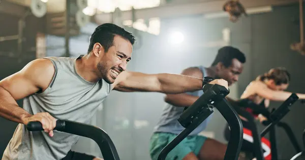 People, diversity and cycling at gym in fitness, workout or intense cardio exercise together and motivation. Diverse group burning sweat on bicycle machine for healthy body, wellness or lose weight.
