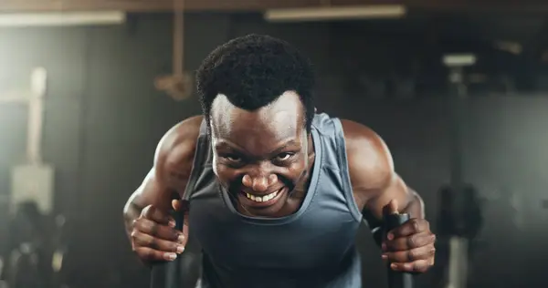 Black man at gym, weight sled and muscle endurance, strong body and core balance power in fitness. Commitment, motivation and bodybuilder in workout challenge for health and wellness on push machine