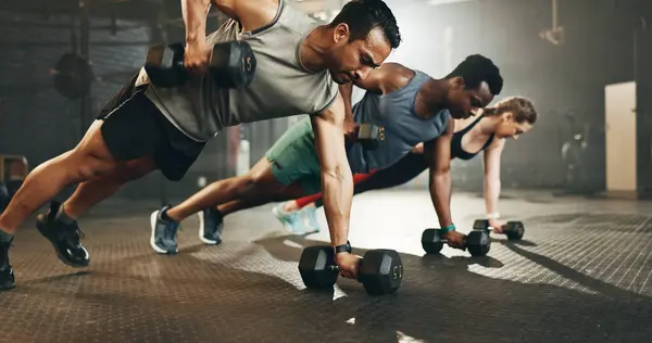 Gym, group and dumbbell rowing exercise for power, muscle and challenge in workout class. Diversity of strong people, bodybuilding and push up with weights for fitness, healthy training and action.
