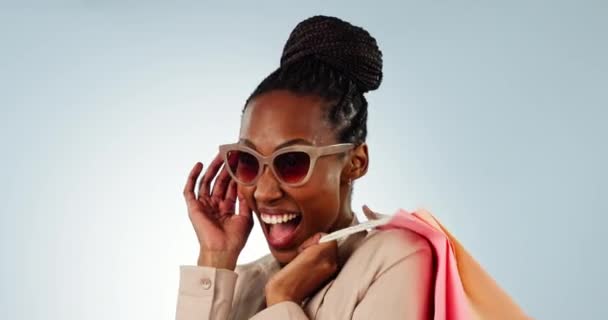 ハッピーブラック女性 ファッション スタイルのサングラス付きの顔とショッピングバッグ スタジオのバックグラウンドで購入 アフリカの女性の人物の肖像画または衣類 割引または販売のための買い物人の笑顔 — ストック動画