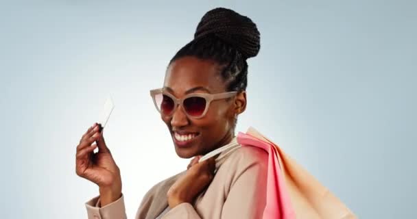 スタジオの背景に対する支払いやEコマースのための興奮した黒人女性 クレジットカード ショッピングバッグ アフリカの女性の人物の肖像画や銀行のための買い物人の笑顔 割引販売やモックアップの取引 — ストック動画