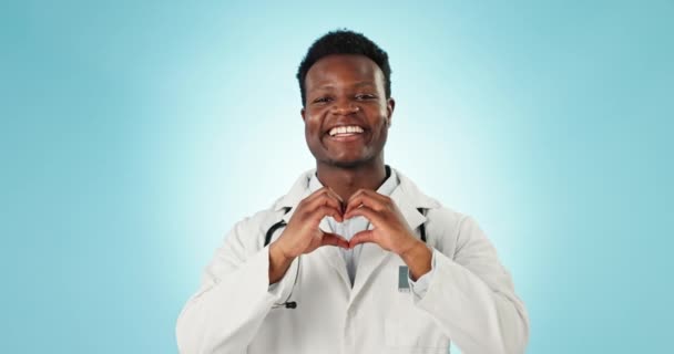 心脏和手的医生在工作室保健 医疗支持和善良的蓝色背景 快乐的非洲心脏科工作者的画像 手指形状和爱心情调 图标和感谢你 — 图库视频影像