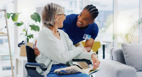 Black man, caregiver or old woman in wheelchair talking or speaking in homecare rehabilitation together. Medical healthcare advice or male nurse nursing or helping elderly patient with disability.