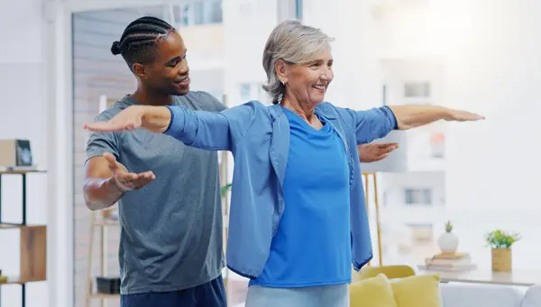 Rehabilitation, elderly woman and nurse for stretching exercise in a nursing home. Happy senior patient with a therapist man for healing, health and physiotherapy for arms, strong muscle and body.