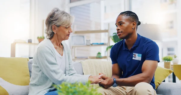 Black man, caregiver or old woman holding hands for support or empathy in cancer rehabilitation. Medical healthcare advice, senior person or male nurse nursing, talking or helping elderly patient.
