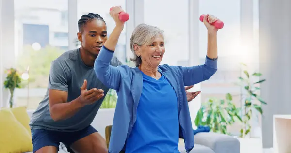 Rehabilitation, strong and woman with a physiotherapist for exercise, strength training and support. Help, fitness and a senior patient lifting dumbbells with black man in physiotherapy for recovery.