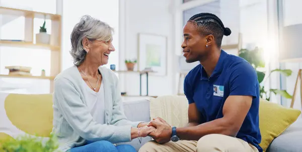 Black man, caregiver or old woman holding hands for support consoling or empathy in therapy. Medical healthcare advice, senior person or male nurse nursing, talking or helping elderly patient