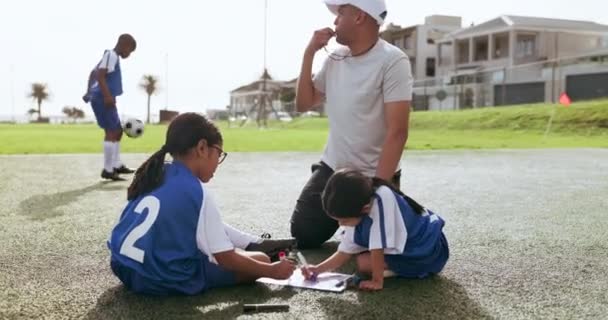 サッカーのためのコーチが付いている計画 クリップボードおよび子供はゲームのために準備し 試合し 屋外で練習します トレーニングスケジュール トーナメントのための子供たちとのスポーツ チームワーク トレーナー — ストック動画