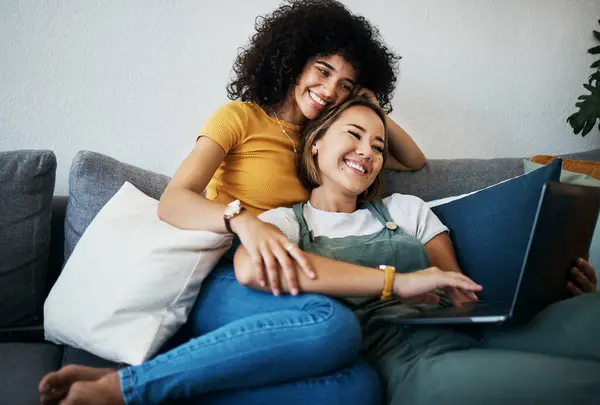 Lgbtq, laptop and couple relax on sofa for watching movies, streaming series and online videos. Dating, lesbian and happy women on computer for internet, bonding and relationship in living room.