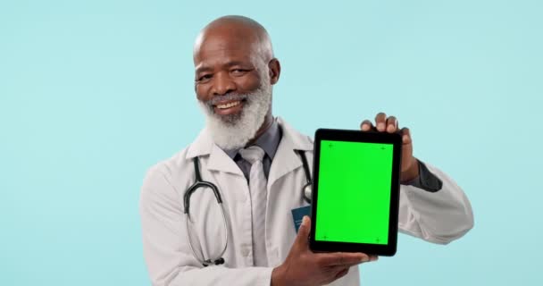 绿屏平板电脑和成熟的黑人男子展示心脏科新闻 医疗公告或医院模拟空间 工作室肖像 在线医学信息和蓝色背景的医疗外科医生 — 图库视频影像