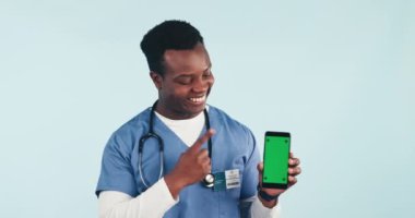 Hemşire, stüdyoda tele sağlık, online sağlık ve uzman tavsiyesi için telefon ve yeşil ekran gösteren siyah bir adam var. Mavi arka planda sağlık uygulaması olan tıbbi profesyonel, bakıcı ya da doktor.