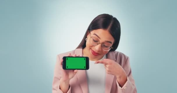 グリーンスクリーン 携帯電話 女性は青い背景のプラットフォーム取引でスタジオで手を指す合意に直面しています 女性モデルのスマートフォン スペース 肖像画がサインアップ アプリ ニュースプロモーションサポート — ストック動画