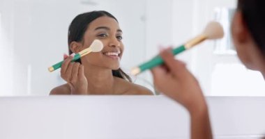 Makyaj, kozmetik ve genç kadın banyoda cazibe için, doğal ya da yüz rutini için aynada. Kozmetoloji, fırça ve Hintli kişi modern ev dairesinde aletlerle yüz bakımı yapıyor.