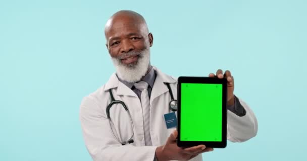 緑のスクリーン タブレットまたは病院のウェブニュース 医学のブランドのロゴまたは商業モックアップスペースが付いている年配の黒人 スタジオの肖像画 オンライン薬のプロモーション または青い背景にあるクリニック外科医 — ストック動画