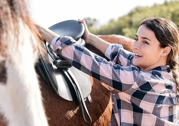 Horse, happy rider and woman with saddle on ranch for animal care, training and riding on farm. Agriculture, countryside and person with seat for stallion for practice, freedom and adventure outdoors.