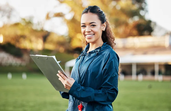 Coach, sports and portrait of woman with clipboard on field for training, planning and game strategy. Happy, writing and personal trainer outdoors for exercise, workout schedule and fitness routine.
