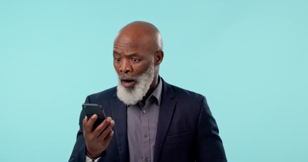 Älterer Mann Lesen Und Telefonieren Mit Überraschung Auf Blauem Hintergrund — Stockvideo