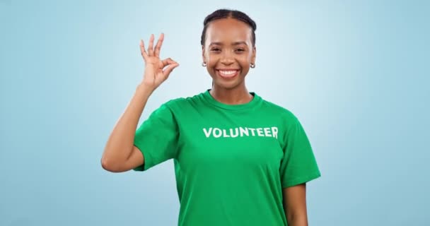 ハッピーな女性 ボランティア そしてチャリティー コミュニティサービス 非営利支援 ウィンクのスタジオで大丈夫です Ngoでボランティア活動するアフリカ人学生の顔と青い背景にイエス絵文字 — ストック動画
