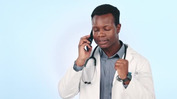 怒っている医師と男性の話 ブルーバックグラウンドのモックアップで隔離されたスタジオでのコンサルティングと議論 スマートフォン イライラしたアフリカの医療従事者 テレヘルスのための会話におけるストレス — ストック動画