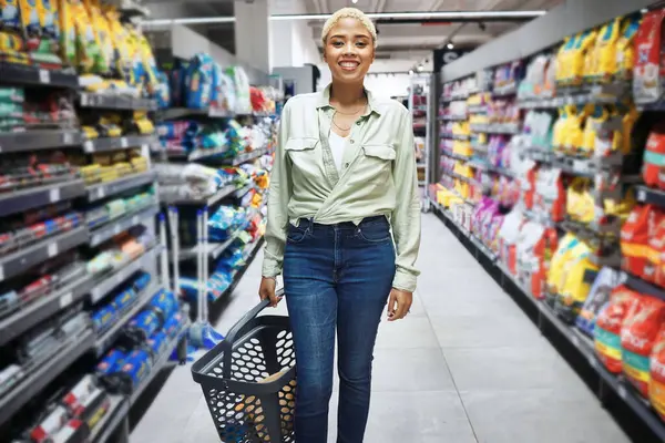 Portrait, basket and happy woman grocery shopping in supermarket, retail and convenience store for food. Groceries, market and African customer smile in shop for product, sales deal and discount
