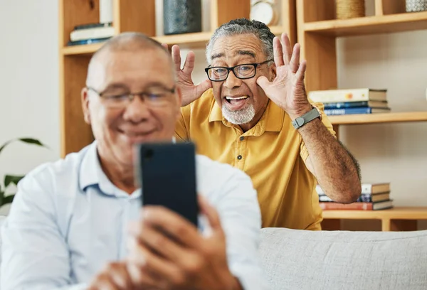 Funny, selfie and men in a house as friends in retirement for relax, comedy and internet. Happy, together and senior or elderly people with a phone for a photo or video call with a comic gesture.